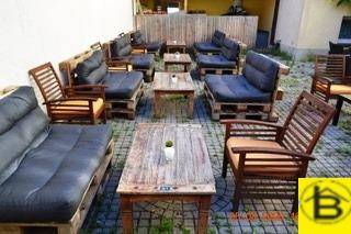 Geräumige Außenterrasse mit Palettenmöbeln und Holztischen, ideal für entspannte Stunden im Freien.