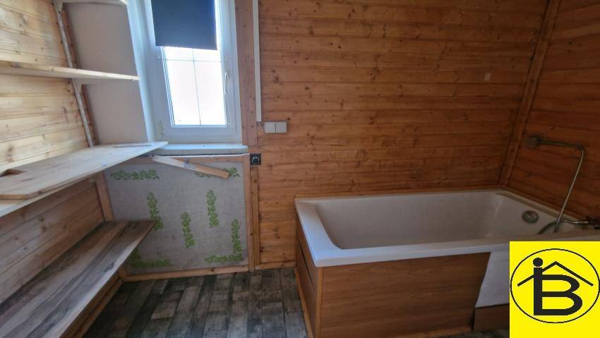 Badezimmer im Ausbau mit Badewanne und Holzverkleidung, bietet Potenzial zur Fertigstellung.