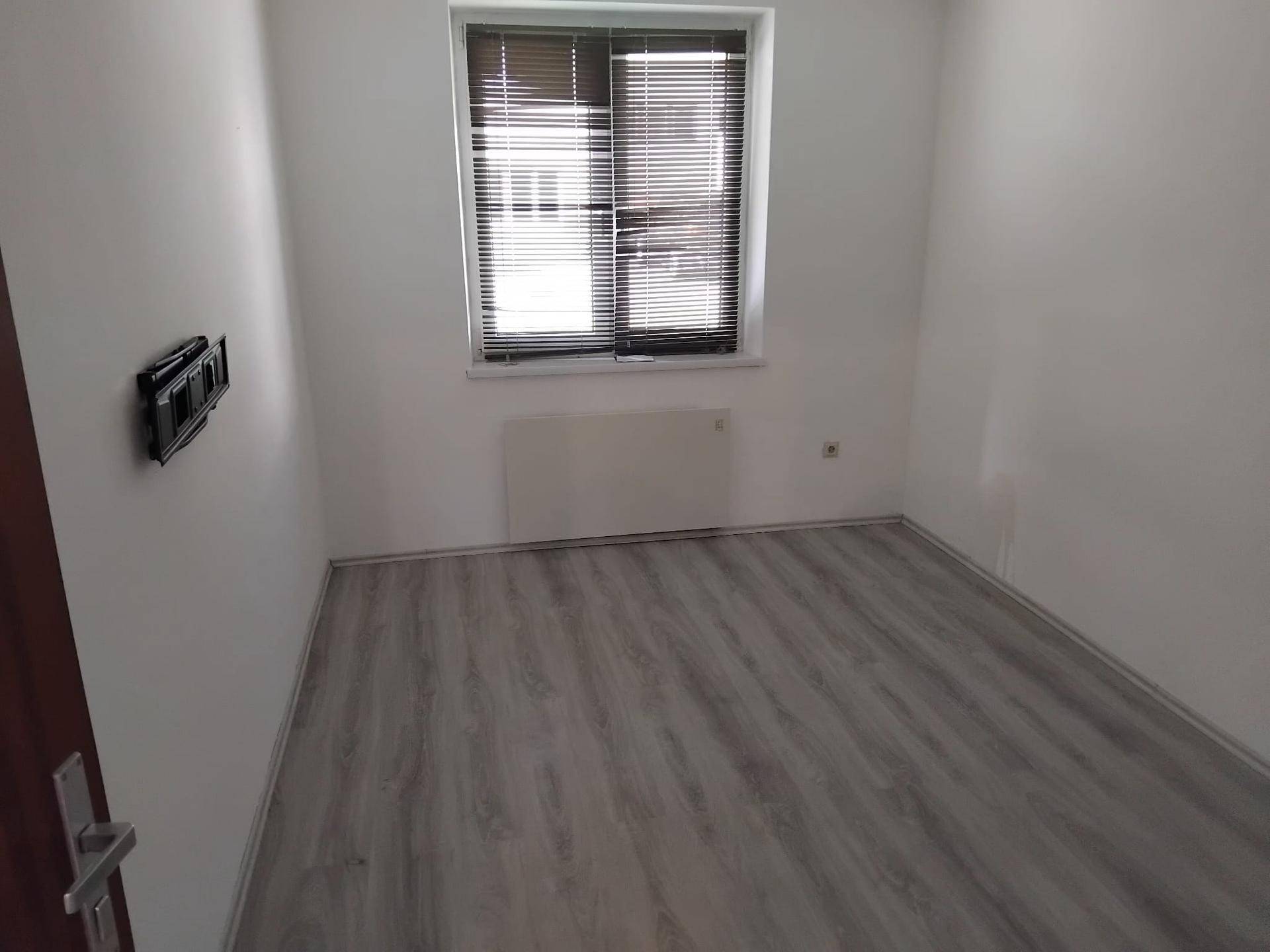 Kleines, helles Zimmer mit Fenster und Jalousien, ideal als Schlaf- oder Arbeitszimmer.