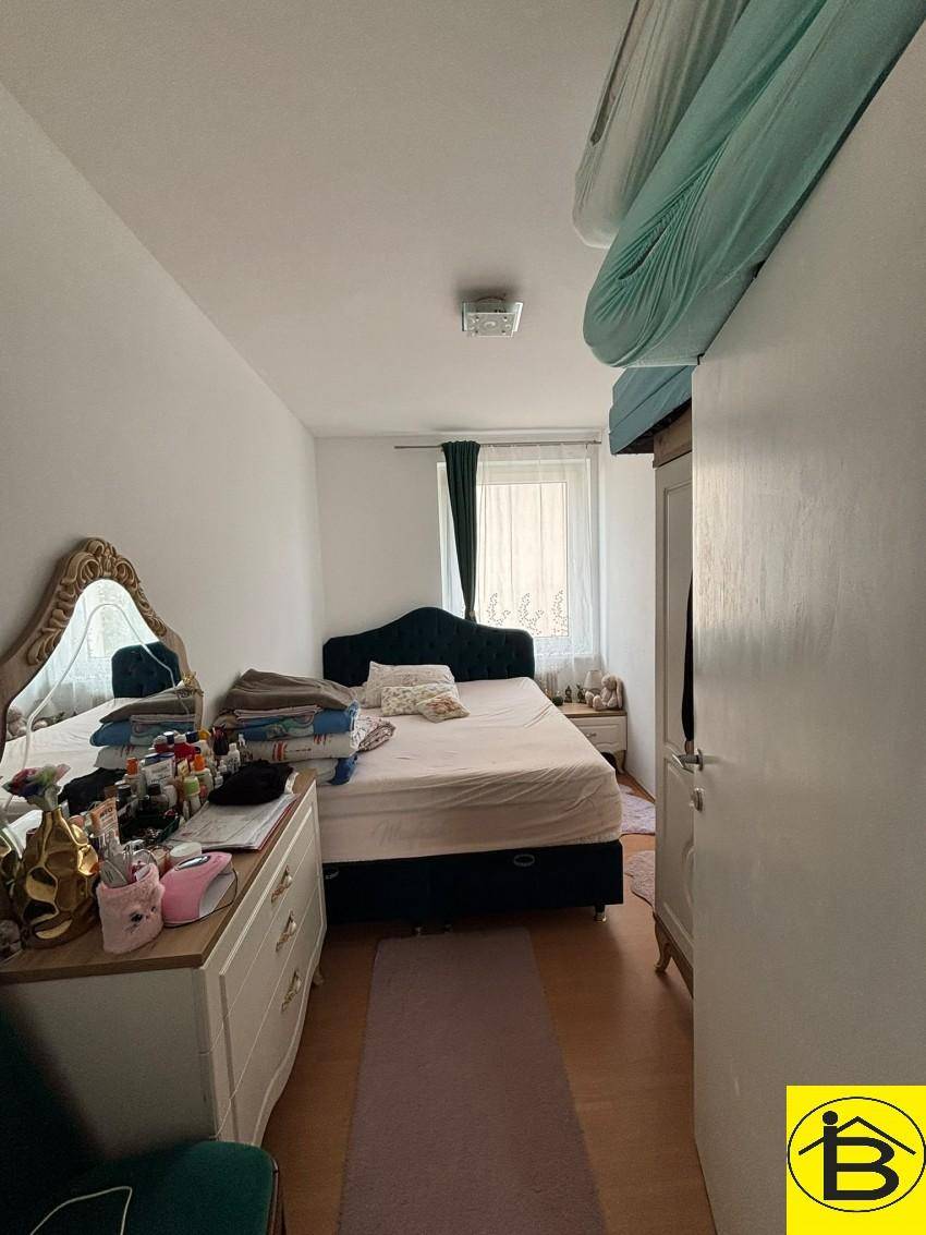 Schlafzimmer mit Doppelbett, Schminktisch und Kleiderschrank, hell und funktional eingerichtet.