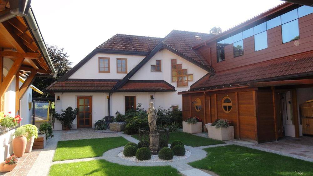 Innenhof mit zentralem Springbrunnen, gepflegten Grünflächen und der Gebäudefassade.