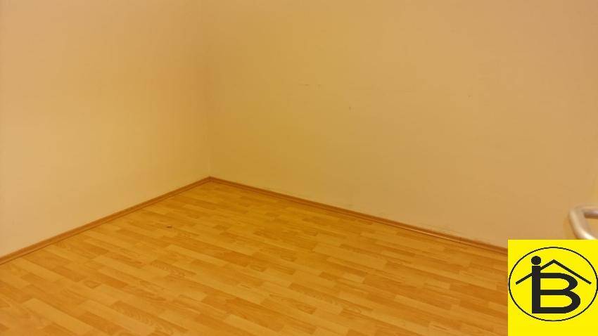Ecke eines Raumes mit hellem Laminatboden und sauberer Wandfläche, bereit zur Nutzung.