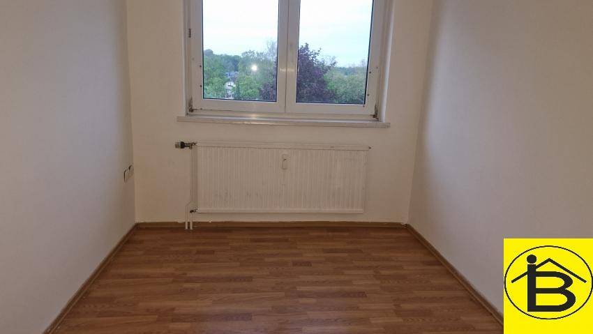Helles Zimmer mit Laminatboden und Fenster, ideal als Kinder- oder Arbeitszimmer.