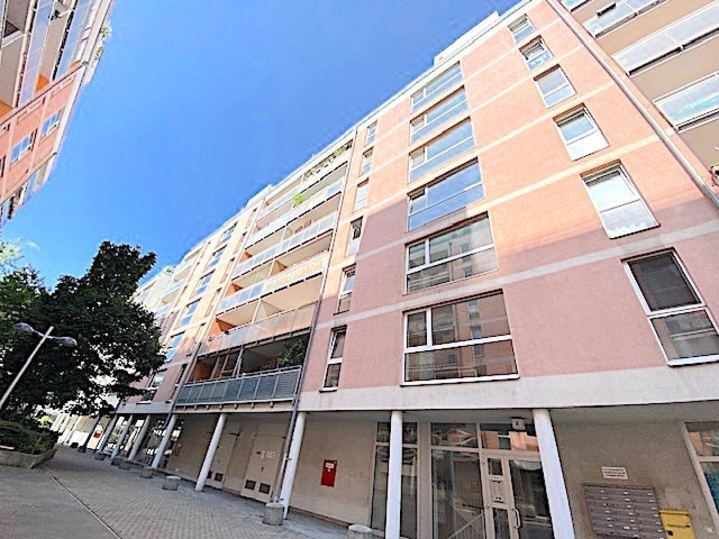 Mehrstöckiges Wohngebäude mit Balkonen und moderner Architektur in städtischer Umgebung.