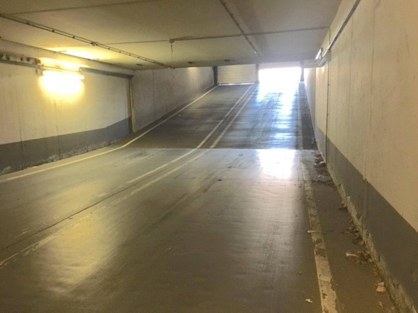 Helle Ausfahrtsrampe der Tiefgarage, die ins Freie führt und Tageslicht hereinlässt.