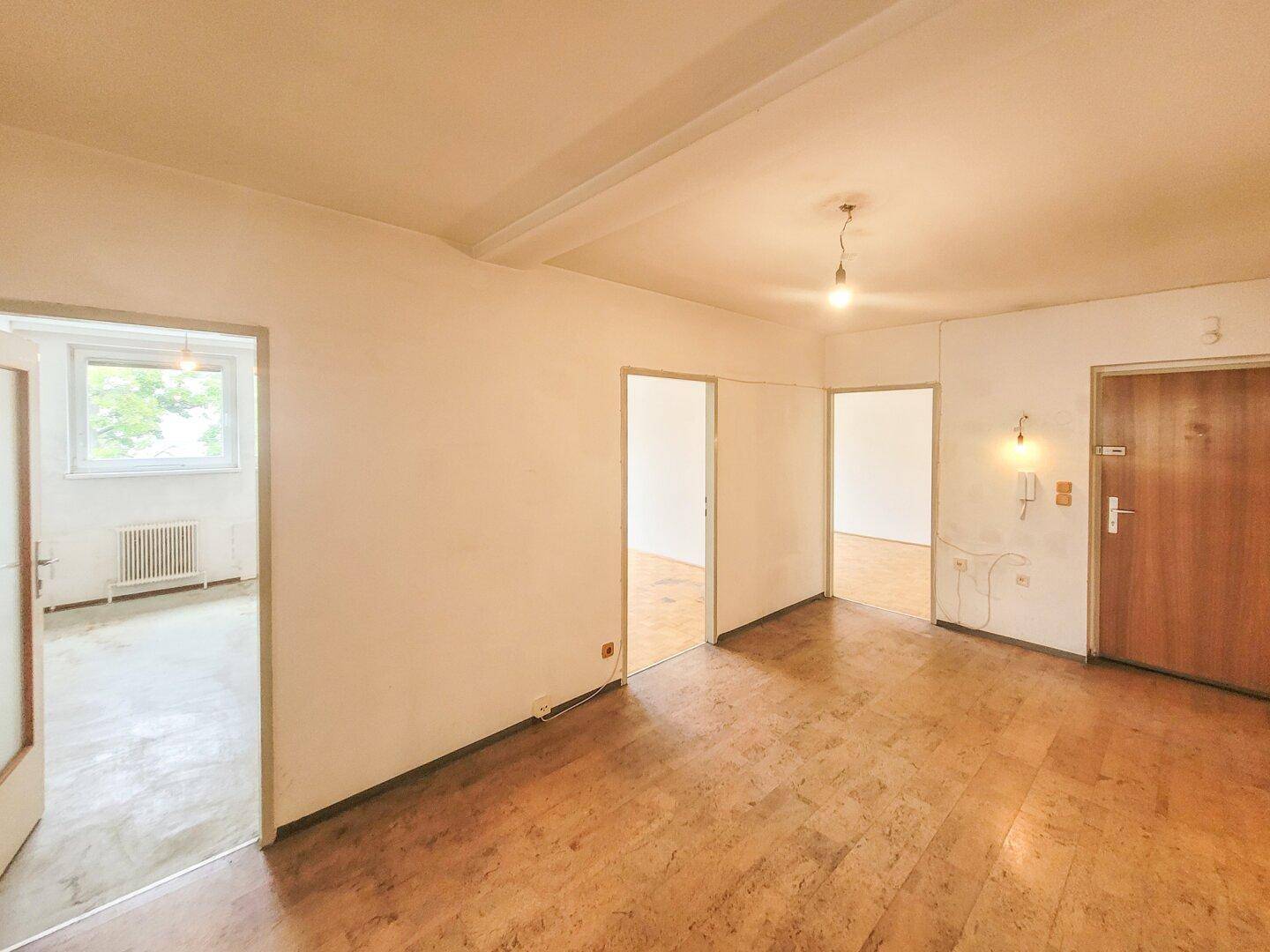Heller Flur mit mehreren Türen, der zu verschiedenen Zimmern der Wohnung führt.