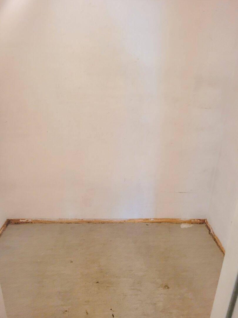 Kleiner, leerer Abstellraum mit Betonboden und weißen Wänden.