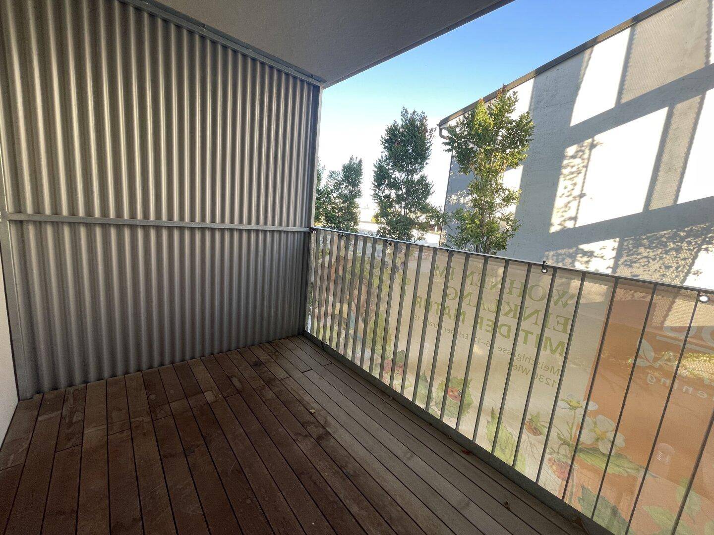 Balkon mit Holzfußboden und Metallgeländer, bietet einen privaten Außenbereich.