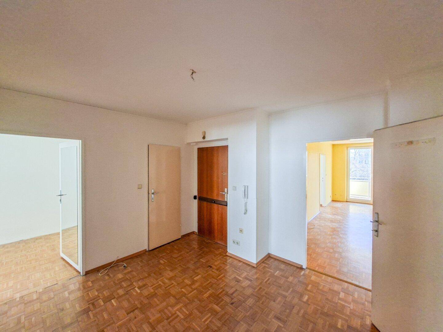 Eingangsbereich mit Fischgrätparkett und Zugang zu den Wohnräumen.