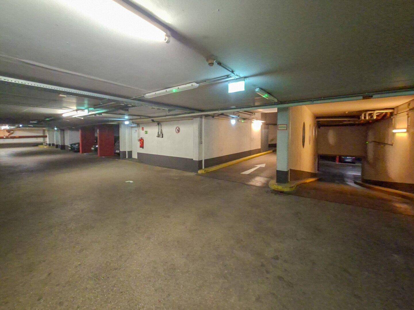 Einfahrt und Ausfahrt der Tiefgarage mit klaren Wegweisern und Beleuchtung.