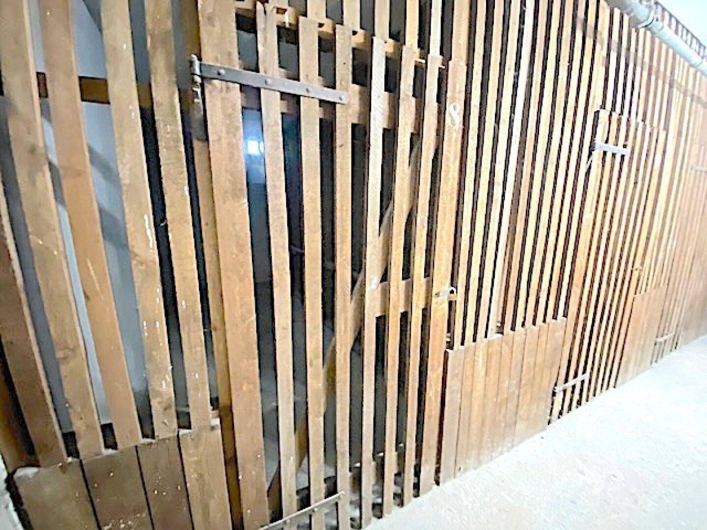 Abstellraum oder Kellerabteil mit Holzlattenwänden für zusätzlichen Stauraum.