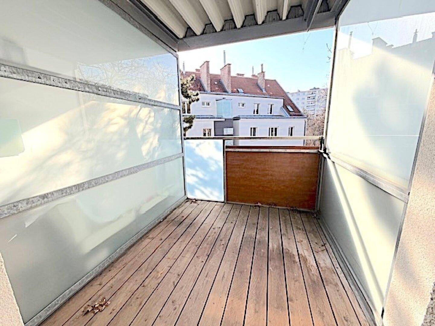 Balkon mit Holzboden und Milchglas-Seitenwänden bietet einen Blick auf die Umgebung.