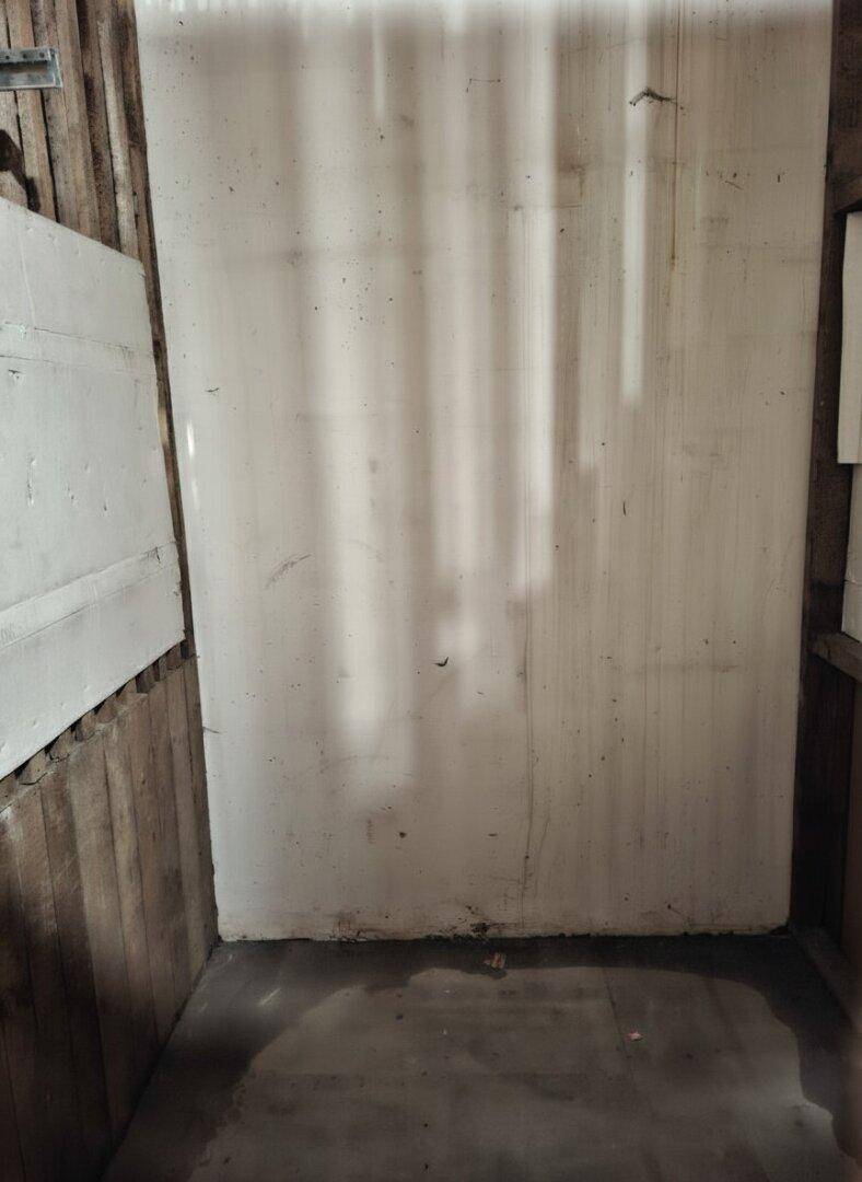 Einfacher Lagerraum mit Holzwänden und Betonboden, ideal für persönliche Gegenstände.