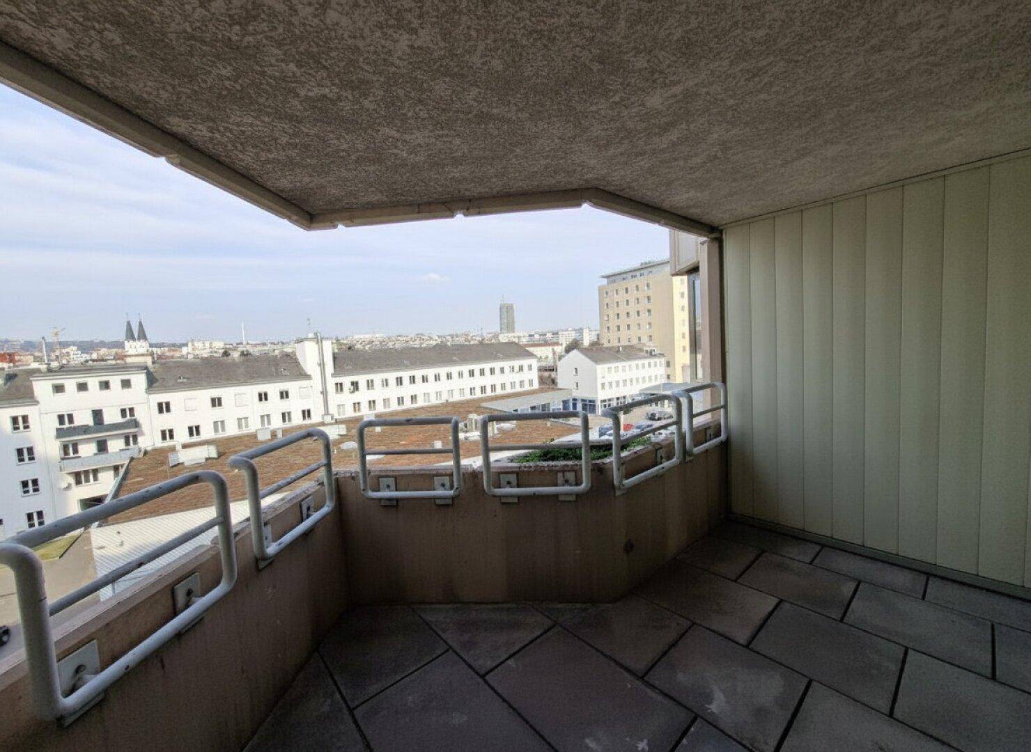 Geräumiger Balkon mit Stadtblick und Fliesenboden, ideal für entspannte Stunden im Freien.
