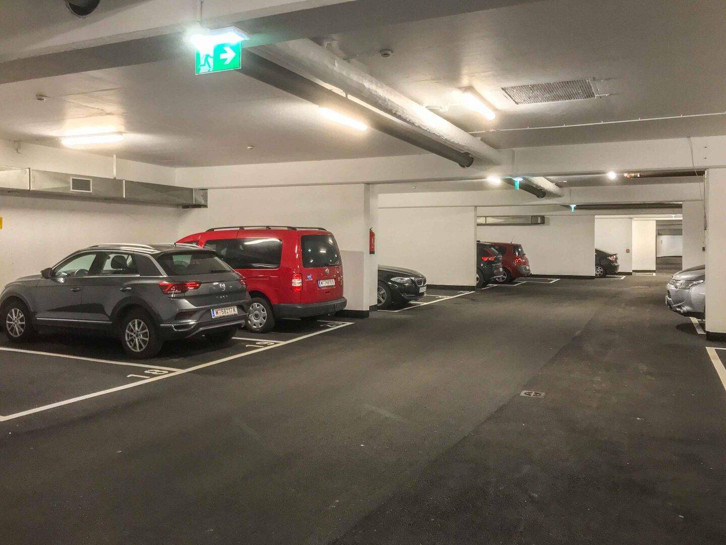 Tiefgarage mit markierten Stellplätzen und Beleuchtung, bietet sichere Parkmöglichkeiten.