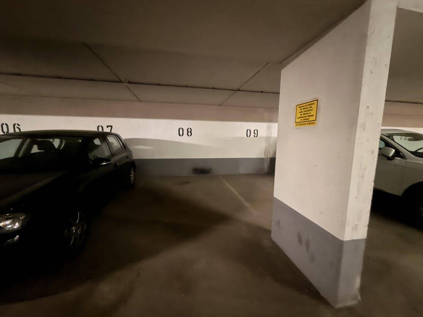 Tiefgaragenbereich mit mehreren nummerierten Stellplätzen und geparkten Autos in einer sauberen Umgebung.