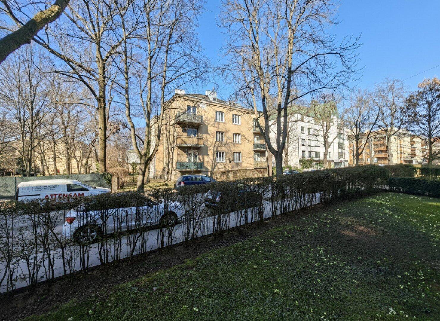 Panoramablick von einem Balkon auf die Wohngegend mit Bäumen und parkenden Fahrzeugen.