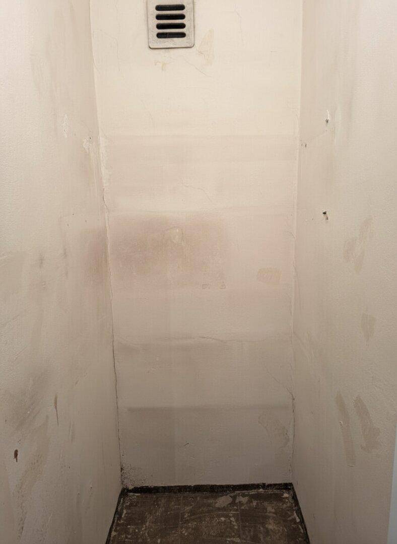 Kleiner Abstellraum oder Nische mit Lüftungsgitter, ideal für zusätzlichen Stauraum.