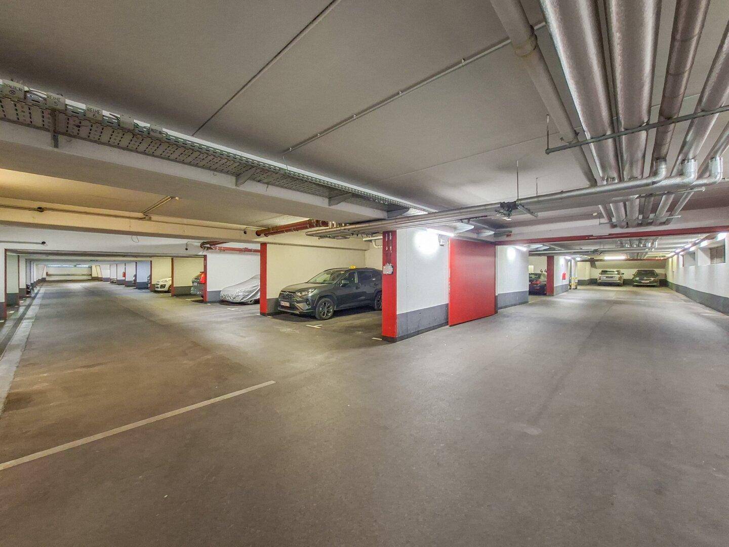 Geräumige Tiefgarage mit markierten Stellplätzen und moderner Beleuchtung.