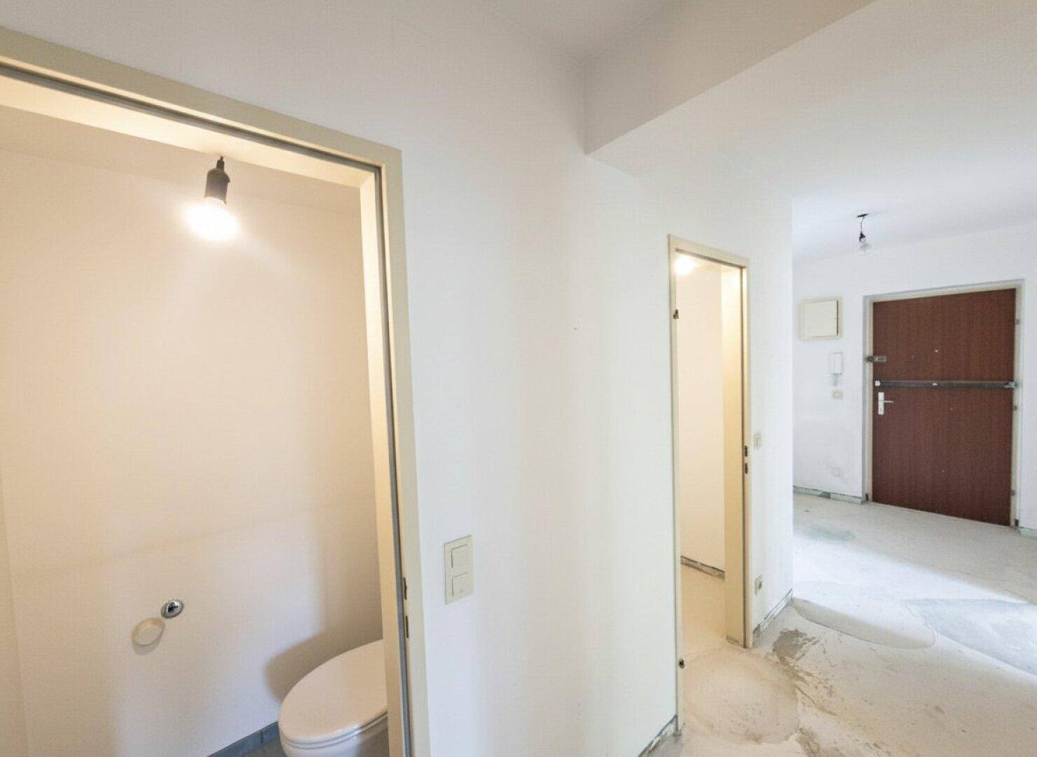 Separates WC mit Toilette und Fliesenboden, direkt vom Flur zugänglich.
