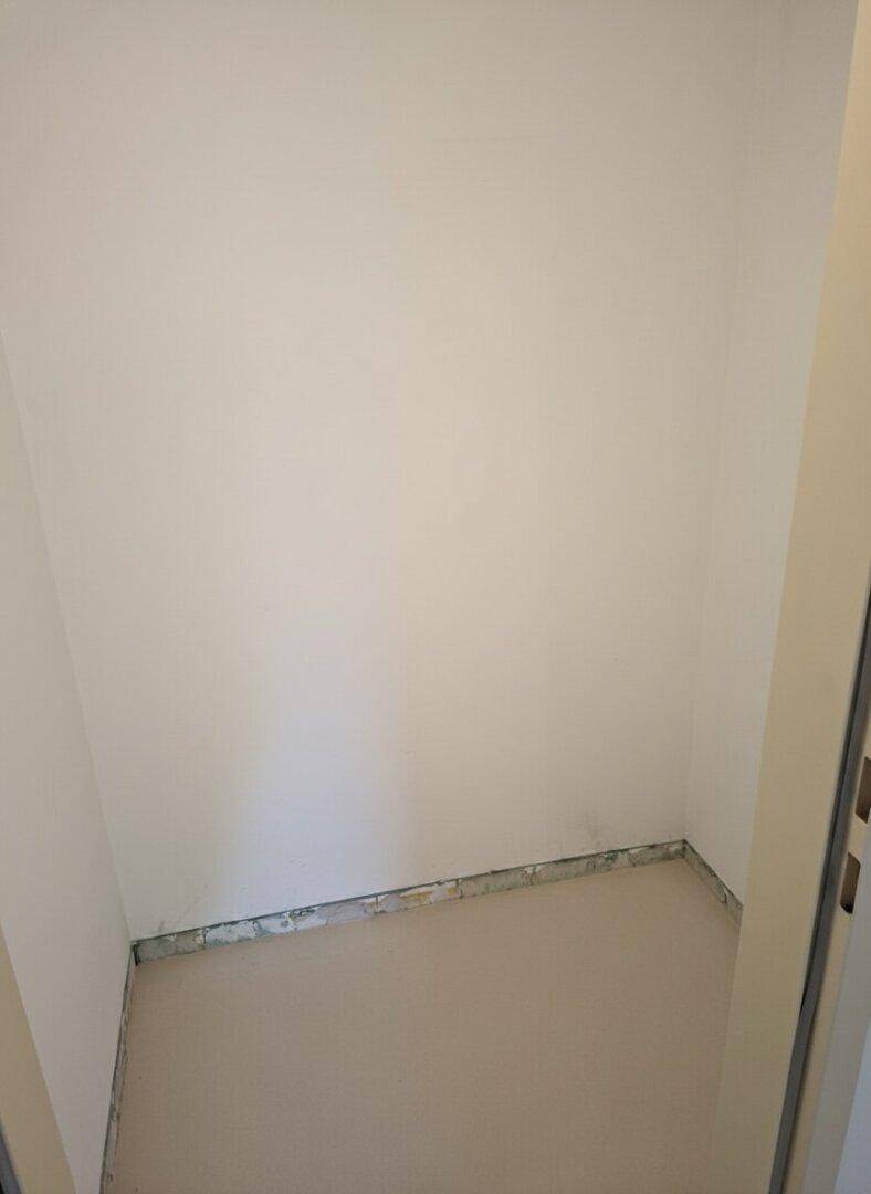 Kleiner, leerer Abstellraum mit Estrichboden, ideal für zusätzlichen Stauraum.