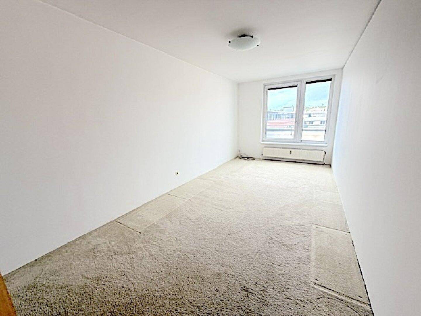 Gemütliches Schlafzimmer mit beigem Teppichboden und großen Fenstern für viel Tageslicht.