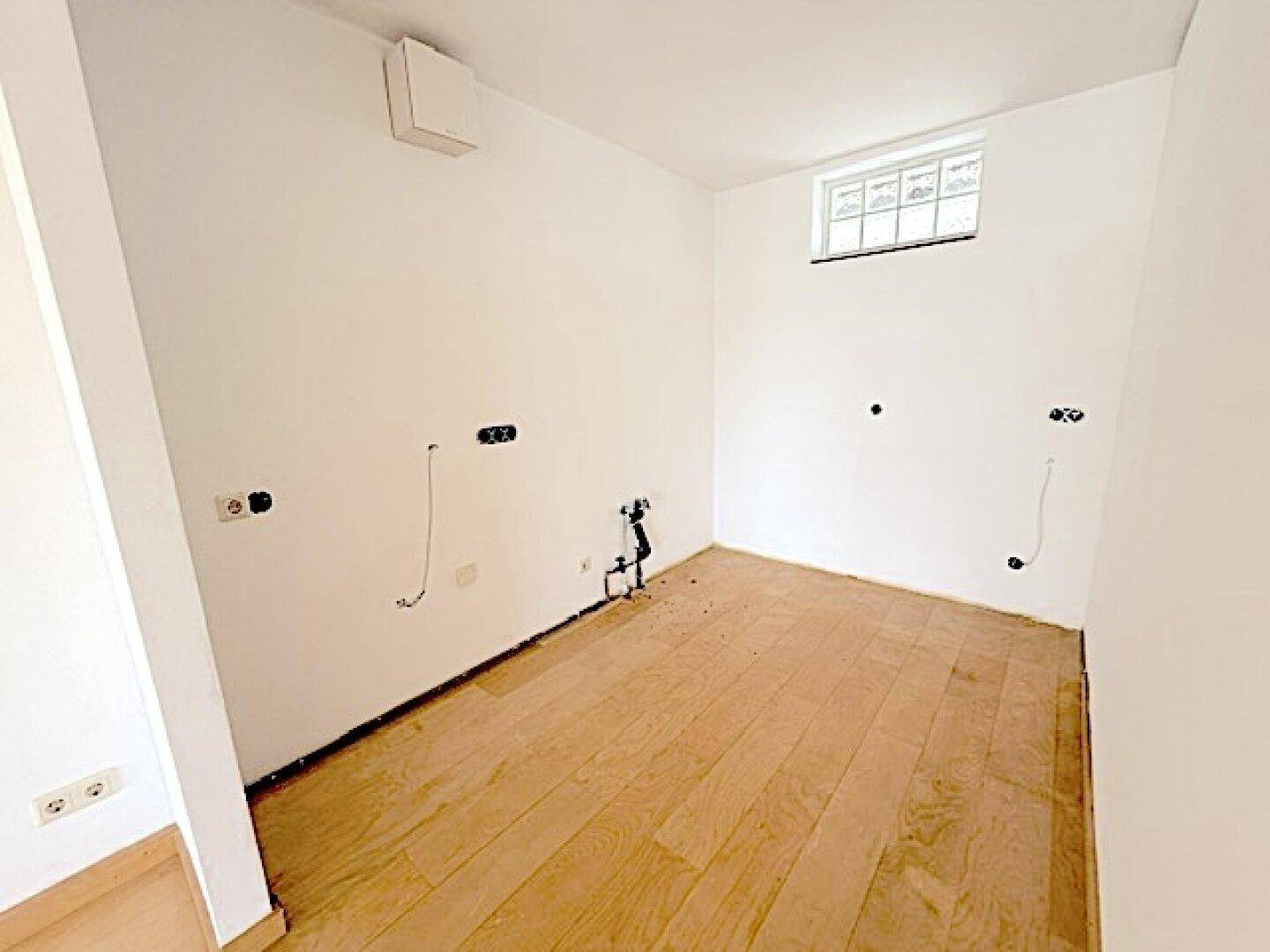 Funktionaler Raum mit Parkettboden und Anschlüssen, vielseitig nutzbar als Abstell- oder Vorratsraum.