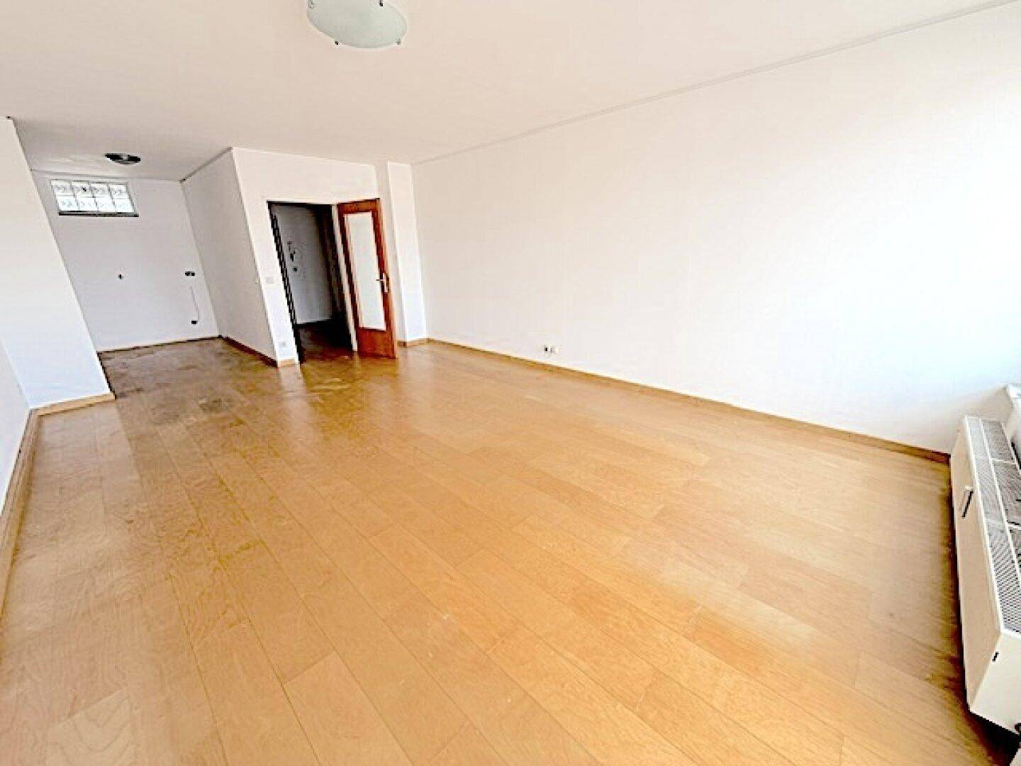 Heller Wohnbereich mit Parkettboden und offenem Übergang, bietet vielseitige Gestaltungsmöglichkeiten.