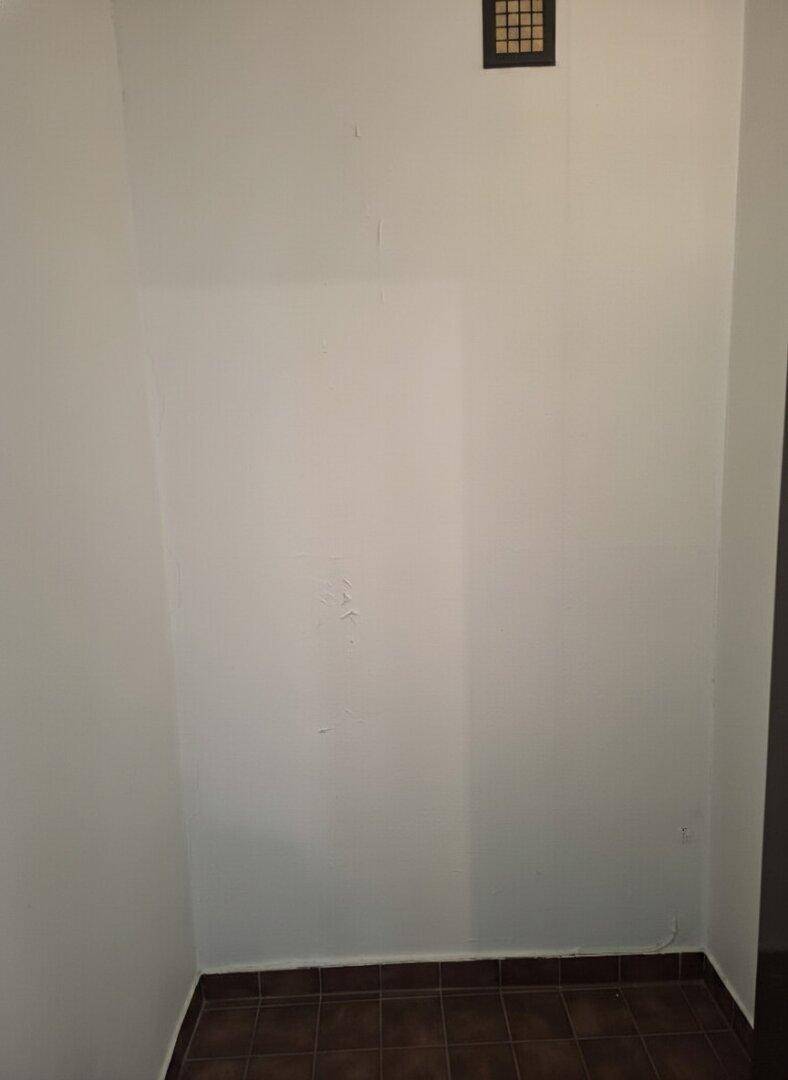 Kleiner, leerer Raum mit Fliesenboden und weiß gestrichenen Wänden, ideal als Abstellraum.