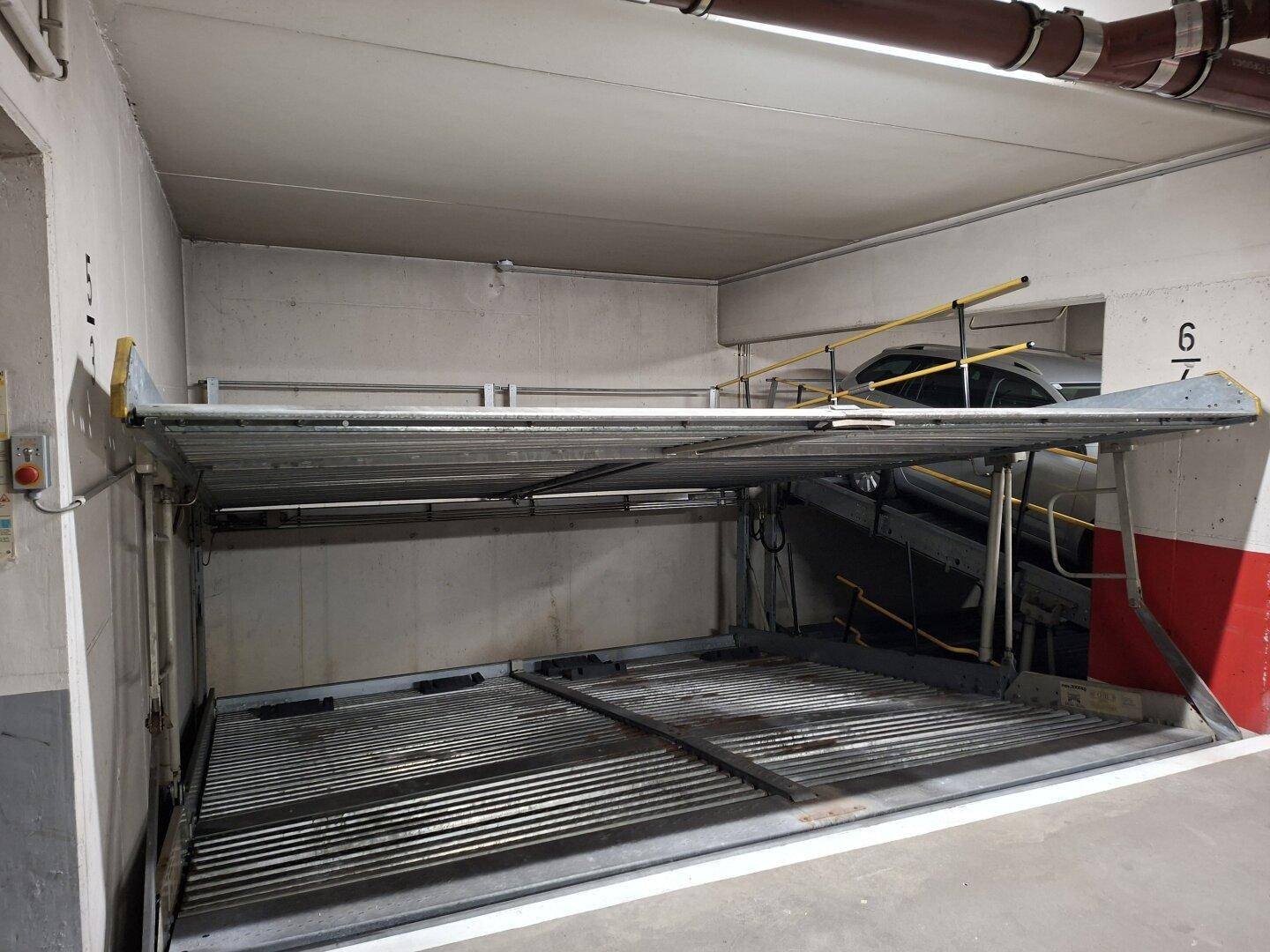 Detailansicht eines automatischen Parksystems in der Tiefgarage mit leerer unterer Plattform.