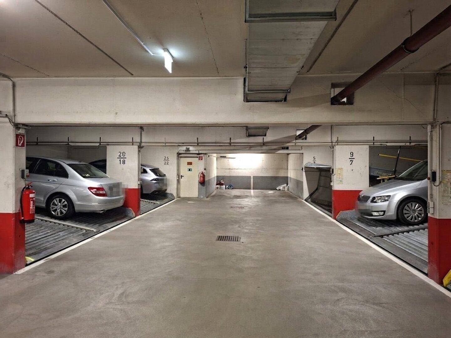Weitere Ansicht der Tiefgarage mit doppelstöckigen Parksystemen für mehrere Fahrzeuge.
