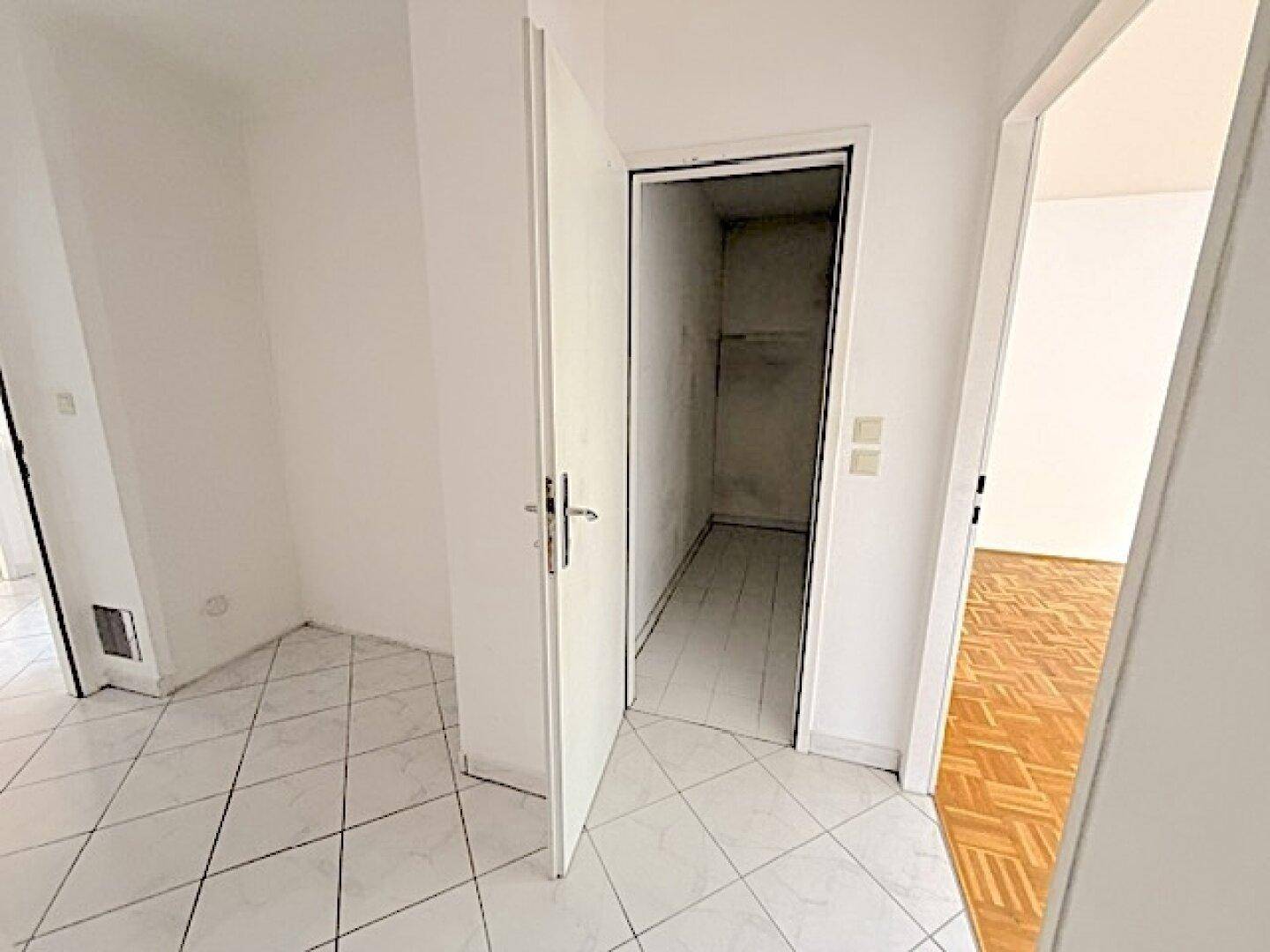 Heller Flur mit Fliesenboden und Zugang zu einem praktischen Abstellraum, der zusätzlichen Stauraum bietet.