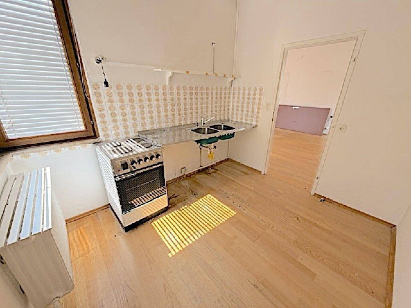 Funktionale Küche mit Doppelspülbecken und Herd, ideal für eine Renovierung.