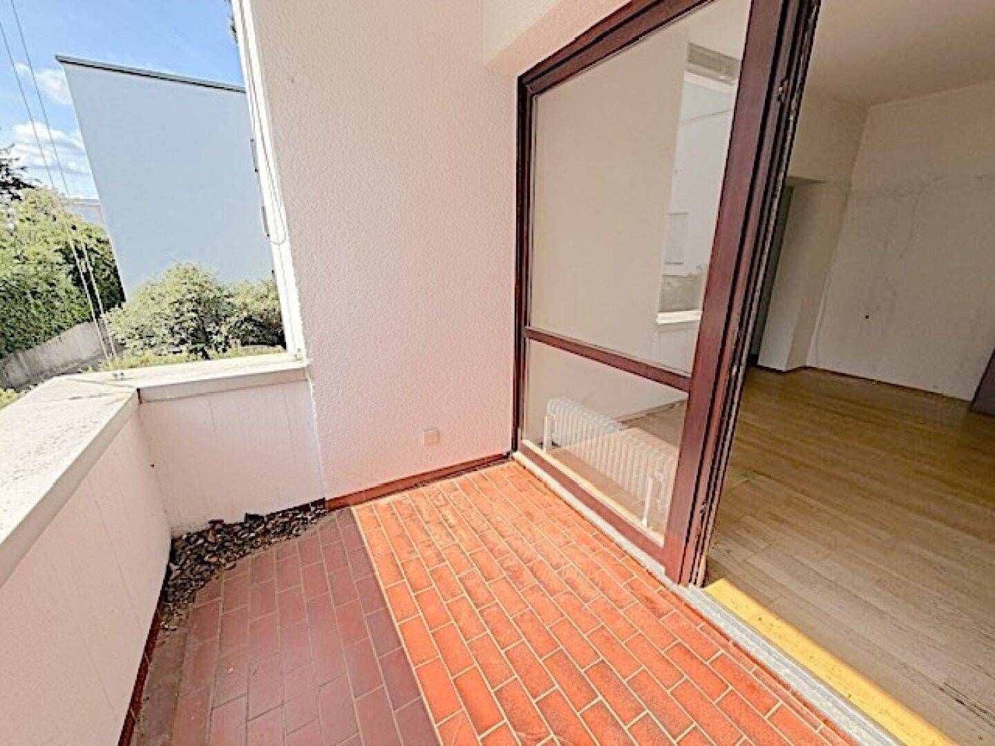 Kleiner Balkon mit Terrakottafliesen und Blick auf die Umgebung, ideal für entspannte Stunden.