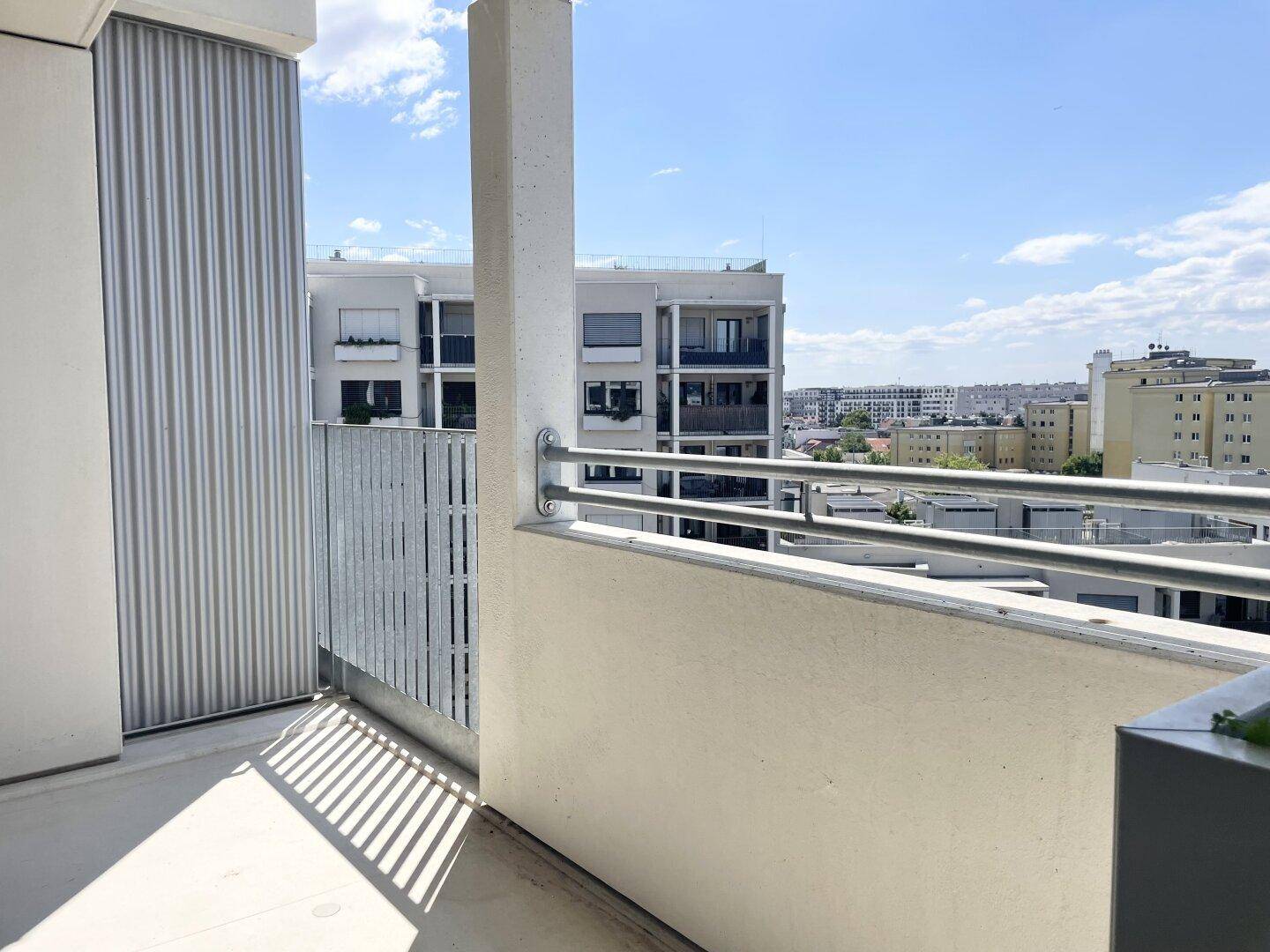 Balkon mit seitlichem Sichtschutz und weitem Blick über die städtische Umgebung.