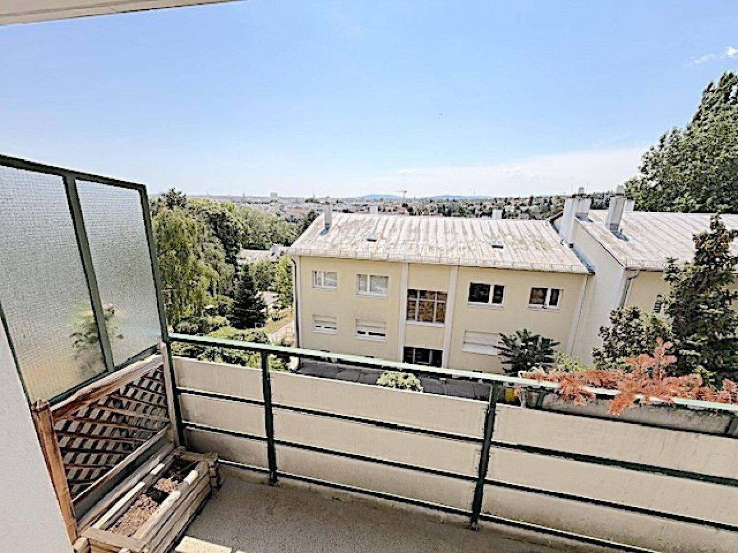 Balkon mit seitlichem Sichtschutz und Ausblick auf die Umgebung.