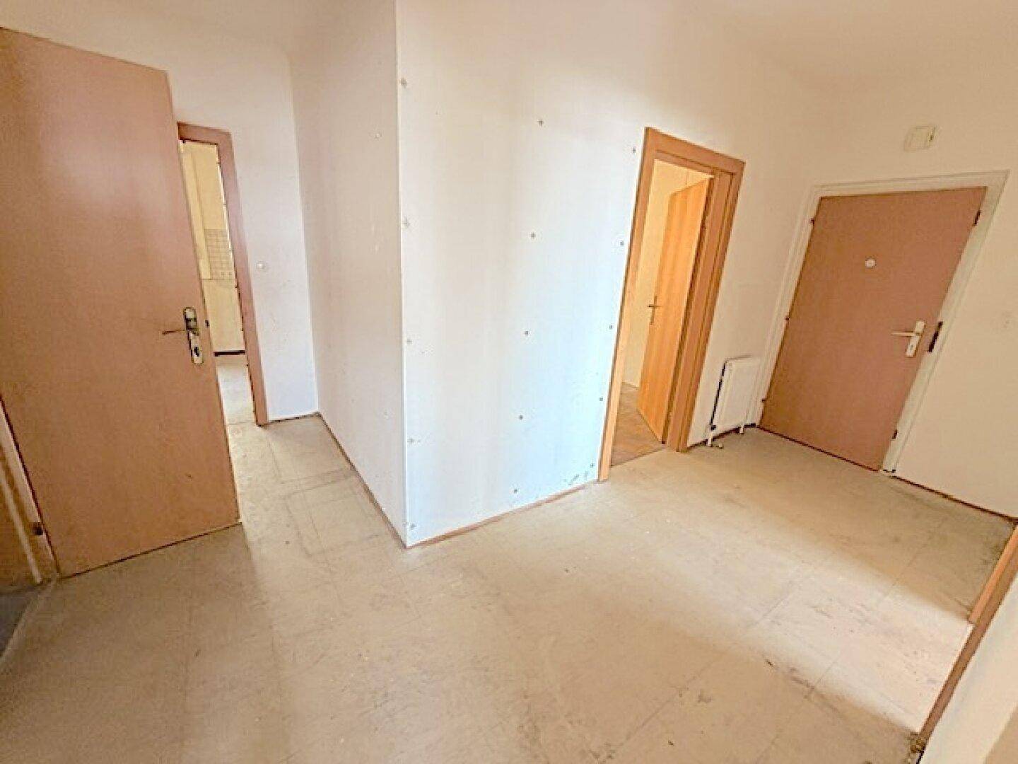 Heller Flur mit mehreren Türen und Zugang zu weiteren Räumen.
