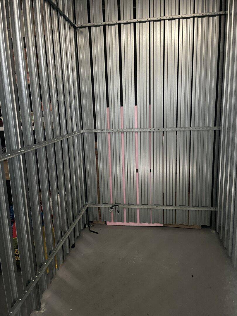 Geräumiger Abstellraum im Keller mit Metallregalsystemen und Betonboden.
