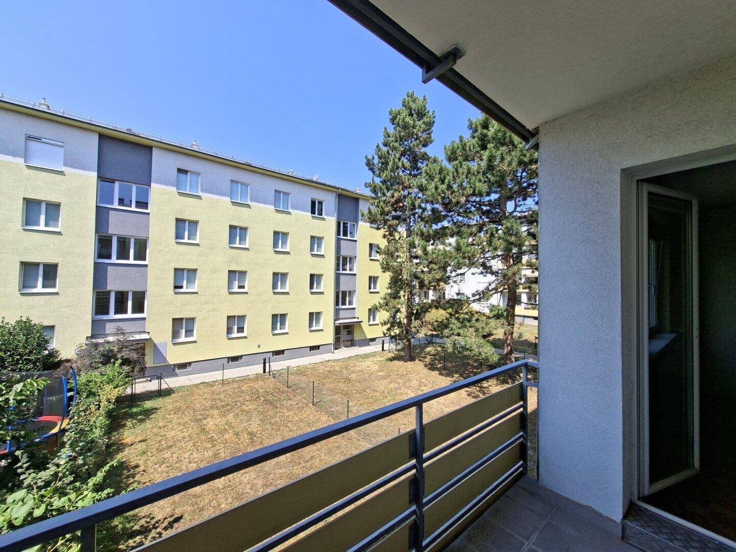 Balkon mit Blick auf den Innenhof und die umliegenden Wohngebäude.