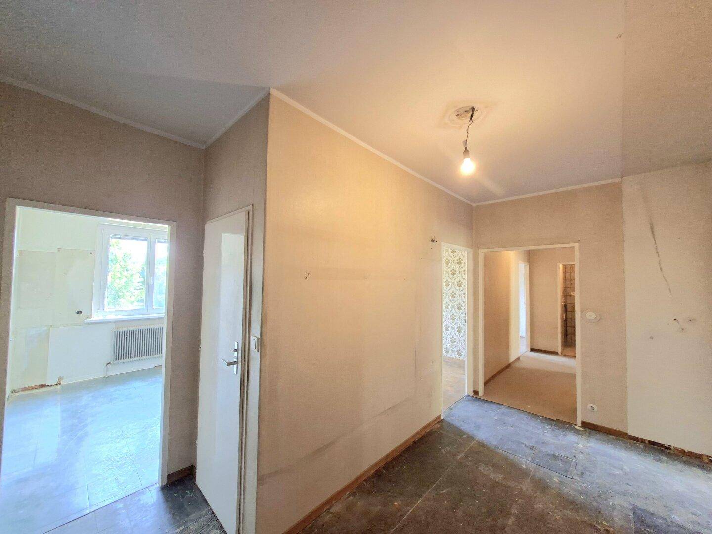 Flur mit Fliesenboden und mehreren Türen zu verschiedenen Zimmern der Wohnung.