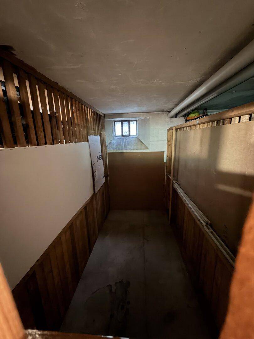 Kellerraum mit Holzverkleidung und kleinem Fenster, ideal als Abstellfläche oder Lager.