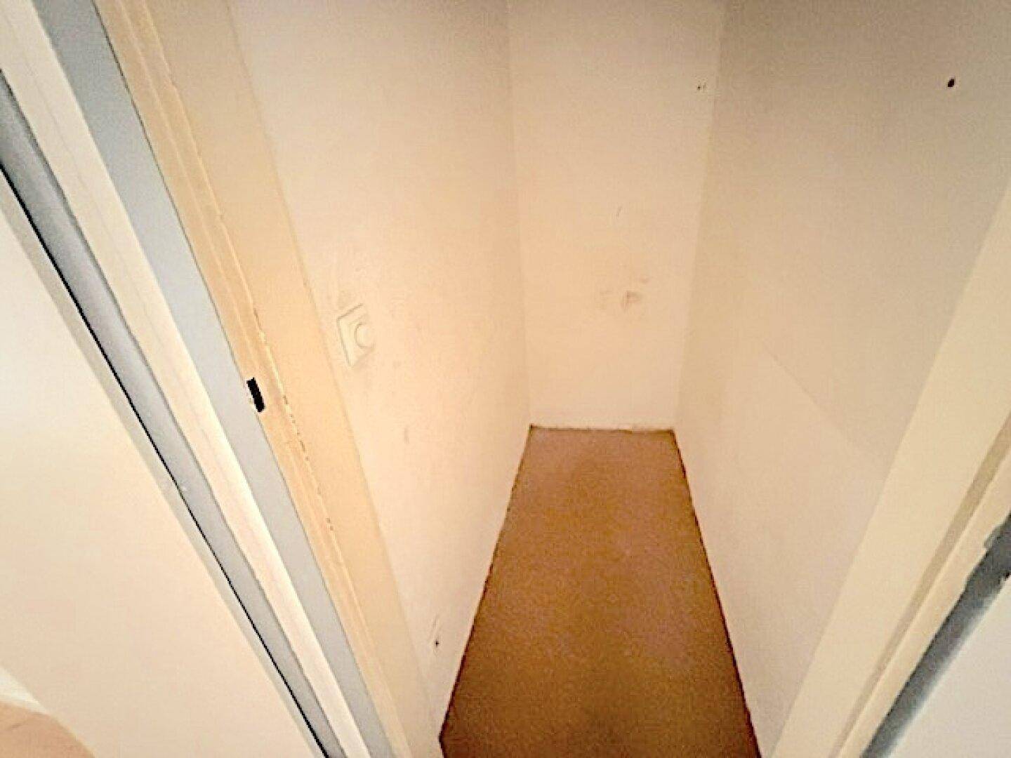 Kleiner Abstellraum mit Teppichboden, ideal für zusätzlichen Stauraum.