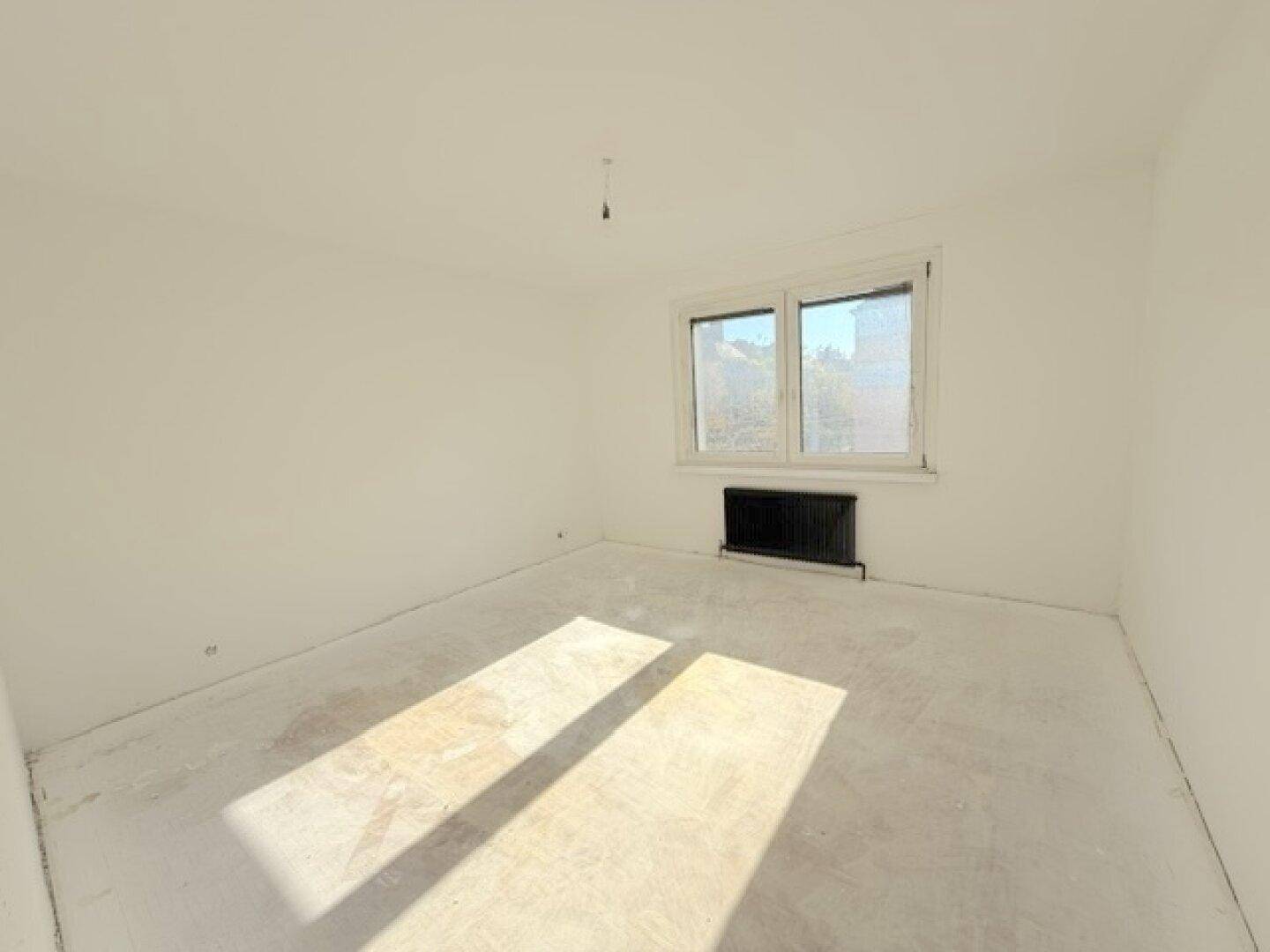 Helles Schlafzimmer mit weiß gestrichenen Wänden und viel natürlichem Licht durch das Fenster.
