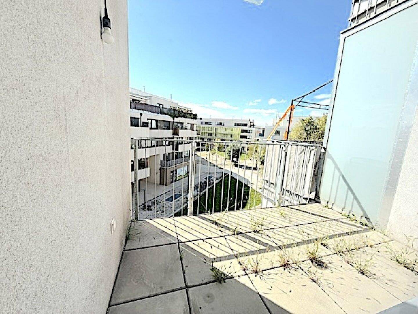 Kleiner Balkon mit Fliesenboden und Metallgeländer, bietet einen Blick auf die Umgebung.