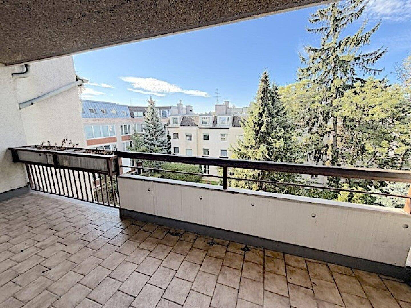 Geräumiger Balkon mit Fliesenboden und weitem Blick auf die Umgebung.