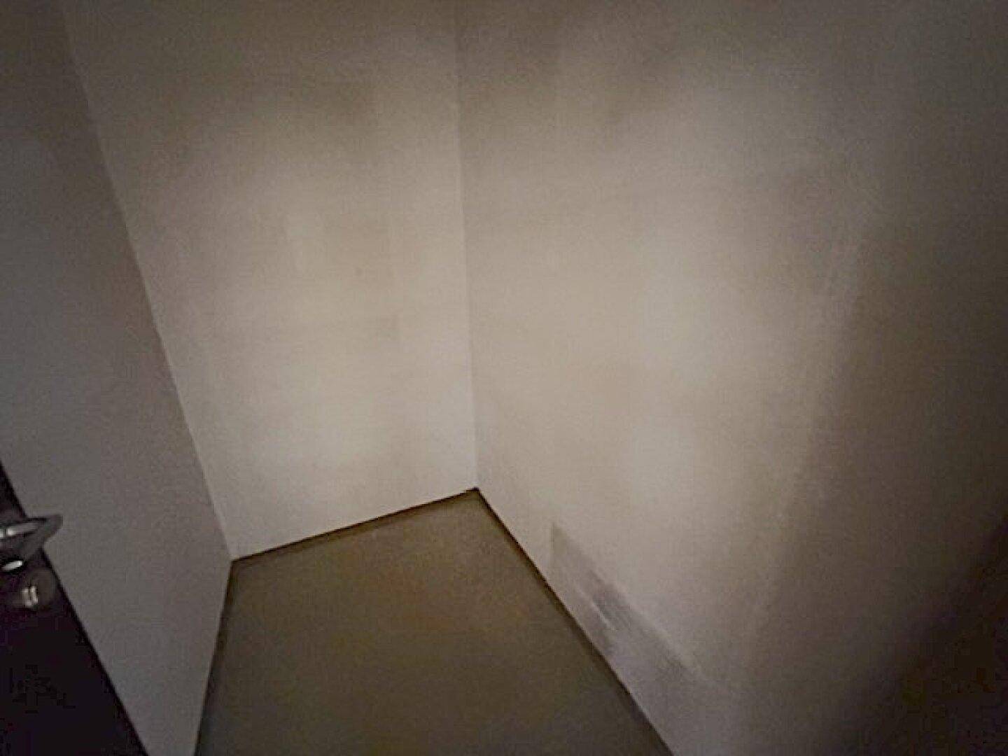 Kleiner, leerer Abstellraum mit einfachen Wänden und Boden.