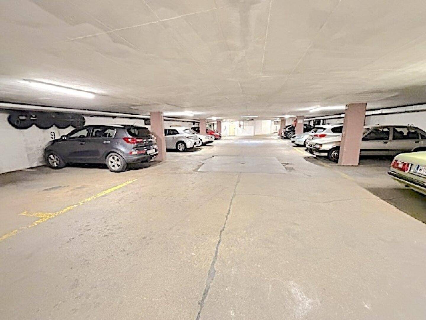 Tiefgarage mit mehreren Stellplätzen und Betonboden.