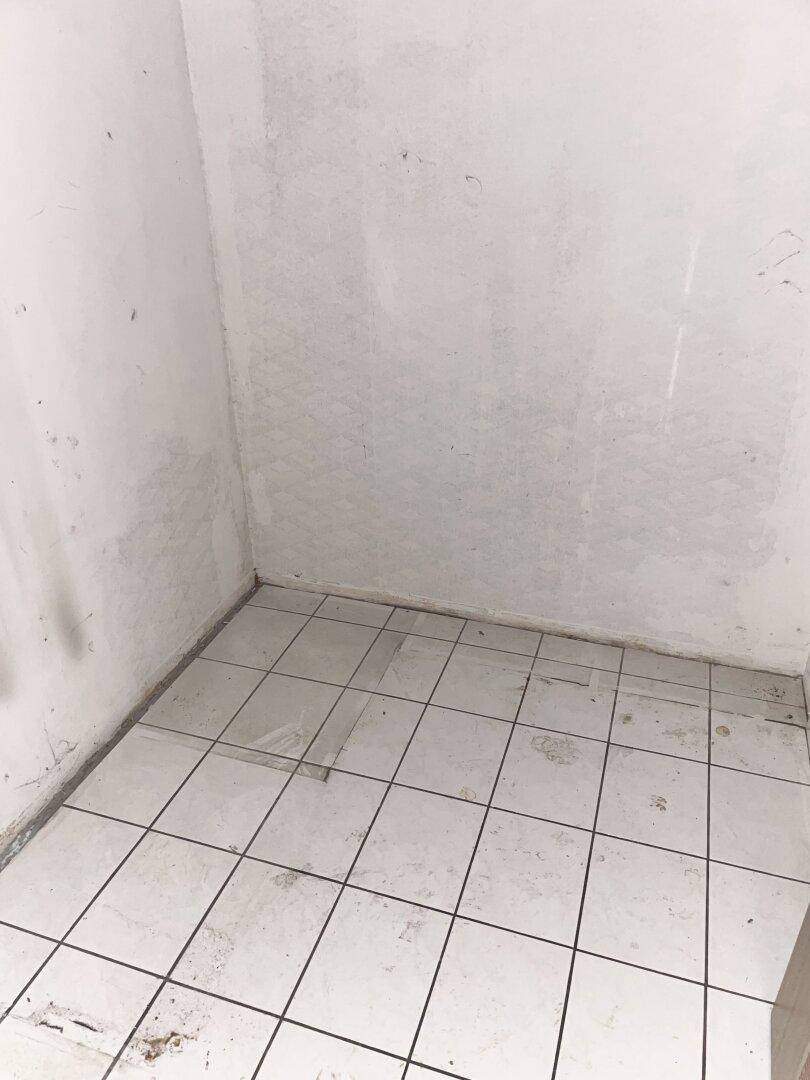 Kleiner Abstellraum mit Fliesenboden und einfachen Wänden, ideal für Lagerzwecke.
