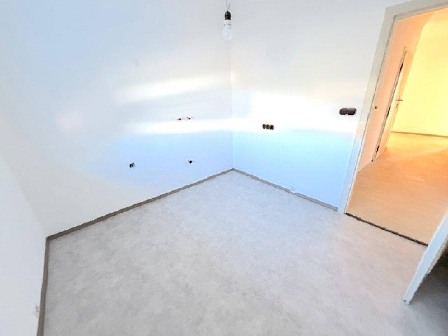 Heller Raum mit Estrichboden und Anschlüssen, bereit für den Ausbau nach individuellen Wünschen.