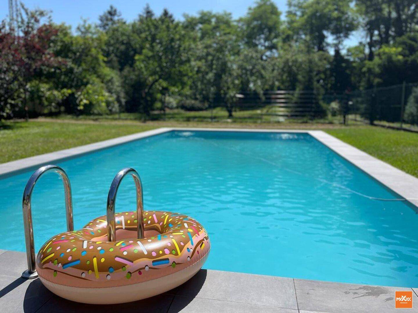 Außenpool mit aufblasbarem Schwimmring und sonniger Umgebung im Garten.